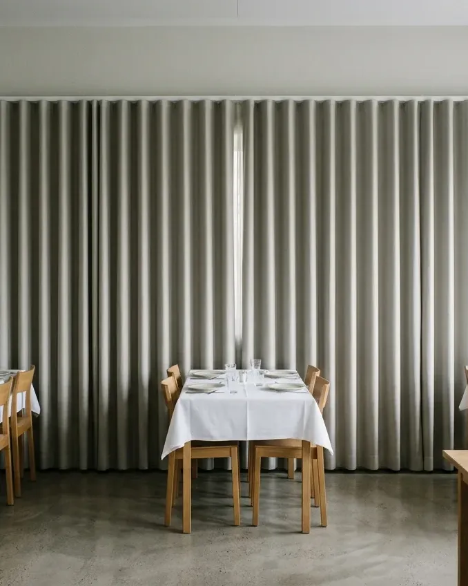 Hotellets matsal med grå draperier längs väggen